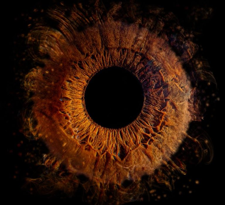 Ein abstraktes, orange-braunes Auge mit dunklem Mittelpunkt und künstlerischen Verzierungen.