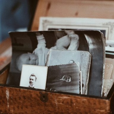 Eine Holzkiste voller alter Schwarz-Weiß-Fotos und Portraits.