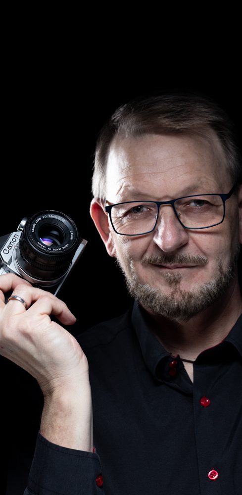 Ich Fotografiere eure Mannschaft Mann mit Bart und Brille hält Kamera