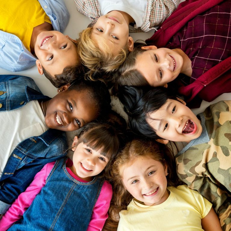 Bilder und Fotogeschenke Mehrere Kinder die mit den Köpfen zusammenliegen und lachen