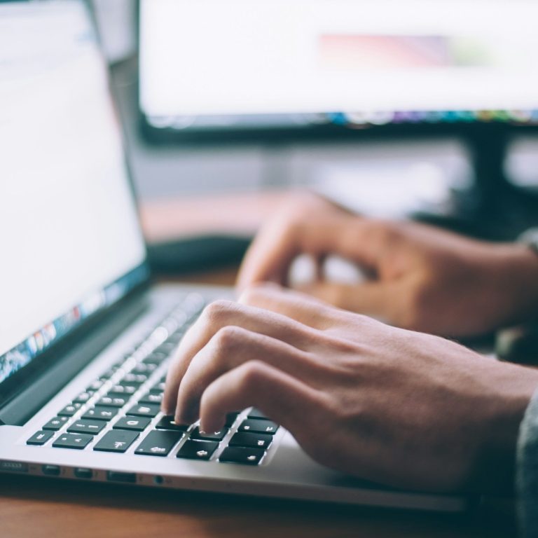 Tim Theissen Businessfotograf Ein aufgeklappter Laptop. Ein Mann sitzt daran und tippt auf der Tasttatur