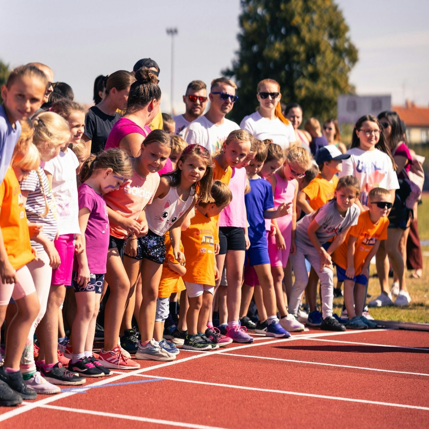 Pay per Download Zuschauer bei einer Sportveranstaltung. Vorne viele Kinder dahinter erwachsene an einem Sommertag
