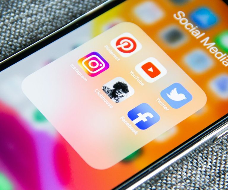 Social Media Content Ein Handy mit allen Social Media Kanälen als Symbol