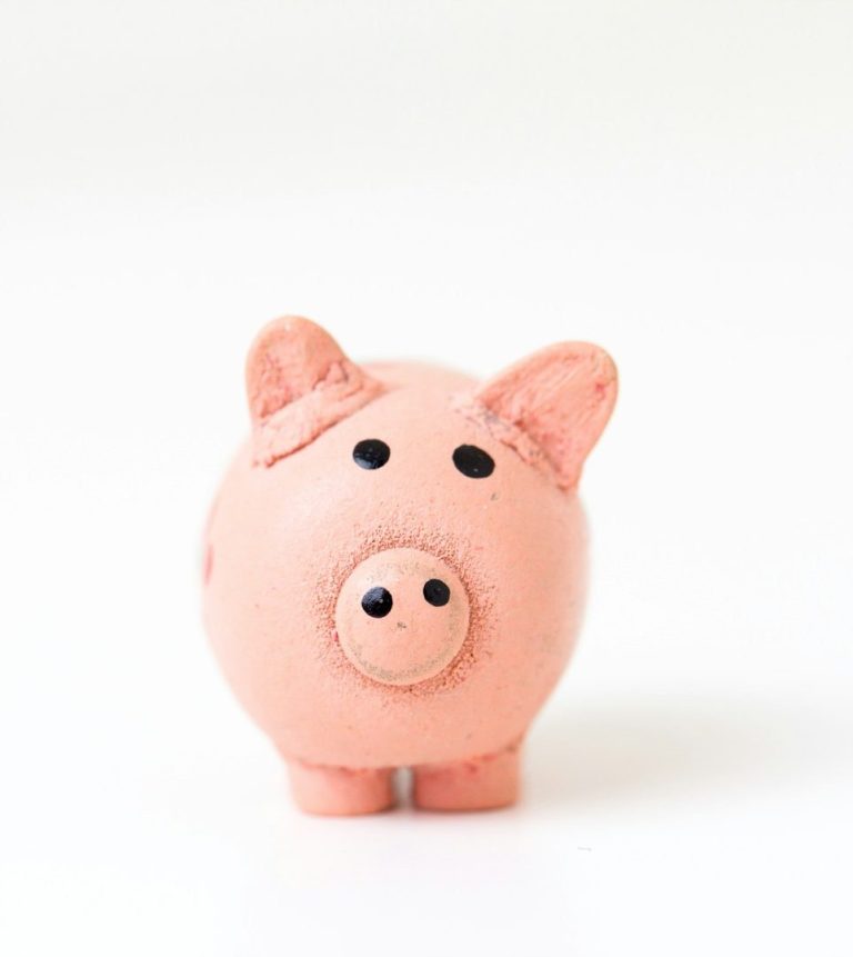 Schweineförmige Sparschwein in Rosa mit schwarzen Augen und Nase.