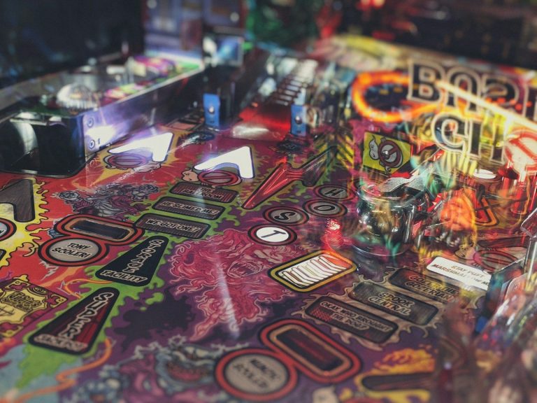 Bunte Pinball-Spieloberfläche mit verschiedenen Lichtern und Designs.
