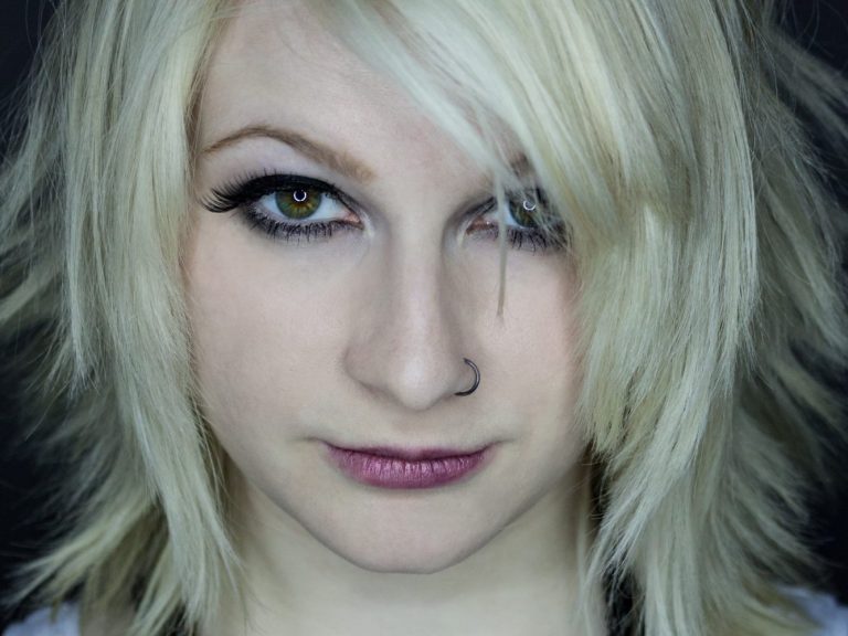 Junge Frau mit heller, stufiger Frisur und ausdrucksvoller Miene.