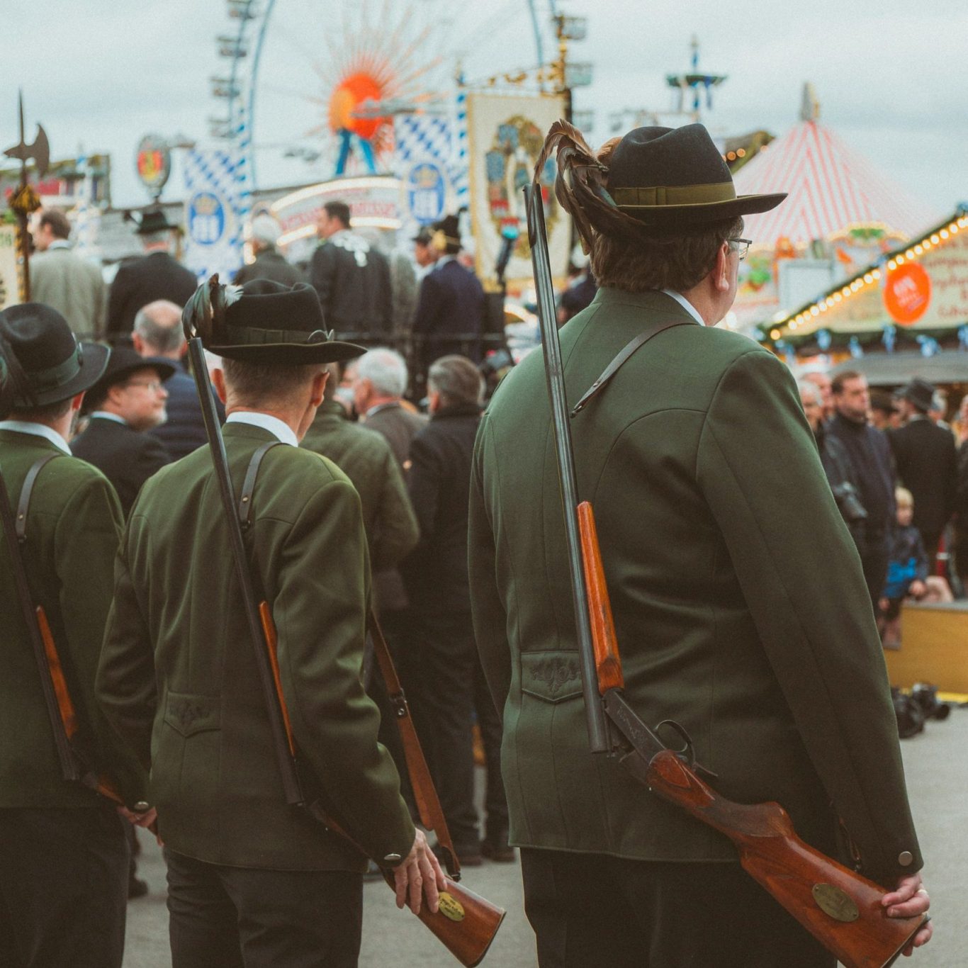 Schützen mit geschultertem Gewähr stehen auf Volksfest