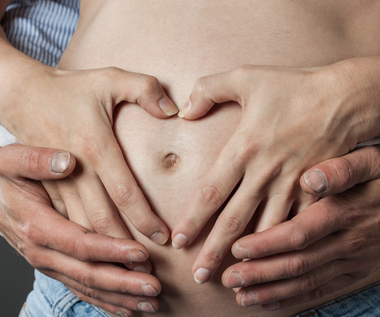 Babybauch Mann und Frau Formen ein Herz auf dem Bau