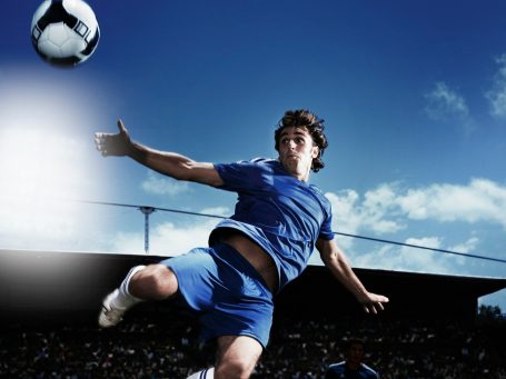Aktionaufnahmen Fußballspieler springt nach Ball