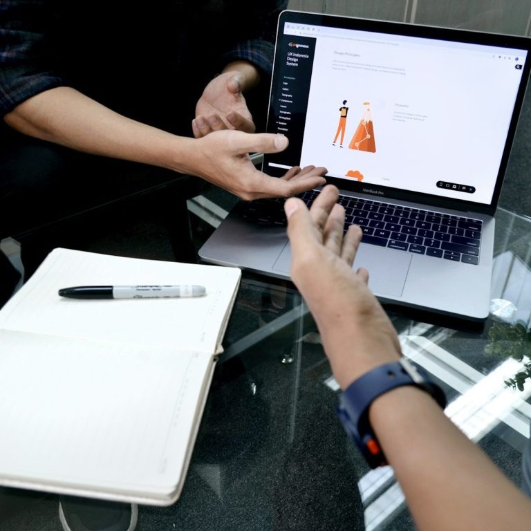 Mitarbeiter Offener Laptop und Hände die Zeigen das man diskutiert