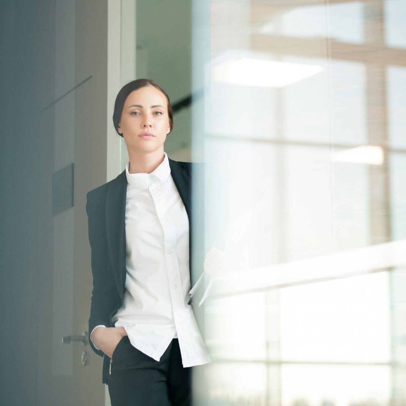 Business Portrait Frau Frau im Anzug und weißem Hemd steht im Eingang