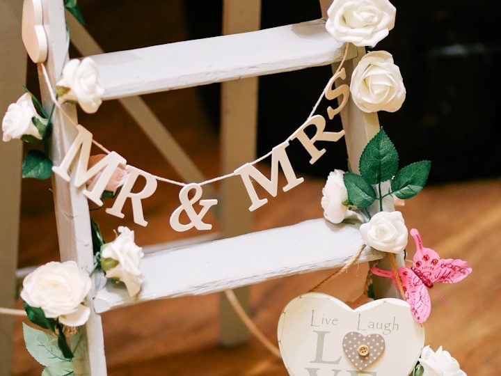 Dekorative Leiter mit "MR & MRS" Schriftzug, Blumen und Herz-Symbol.
