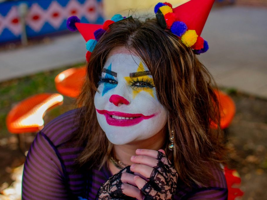 Besondere Momente Frau mit langen Haaren und Clownschminke im Gesicht