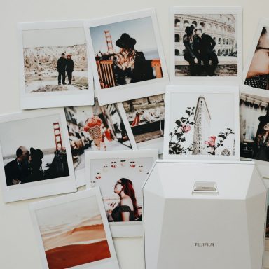 Eine Sammlung von polaroidartigen Fotos auf einem Tisch, umgeben von einer weißen Box.